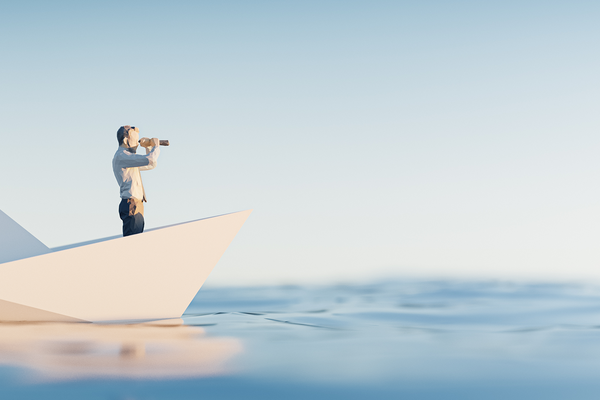 Mann auf Boot schaut mit Fernglas in den Horizont