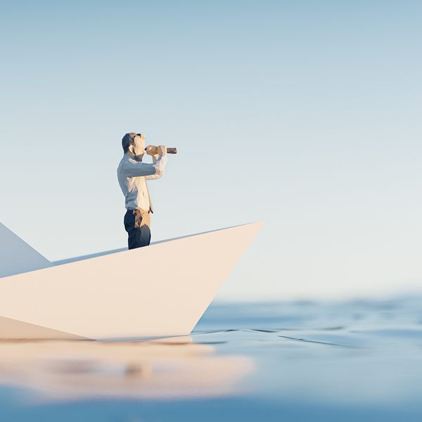 Mann auf Boot schaut mit Fernglas in den Horizont